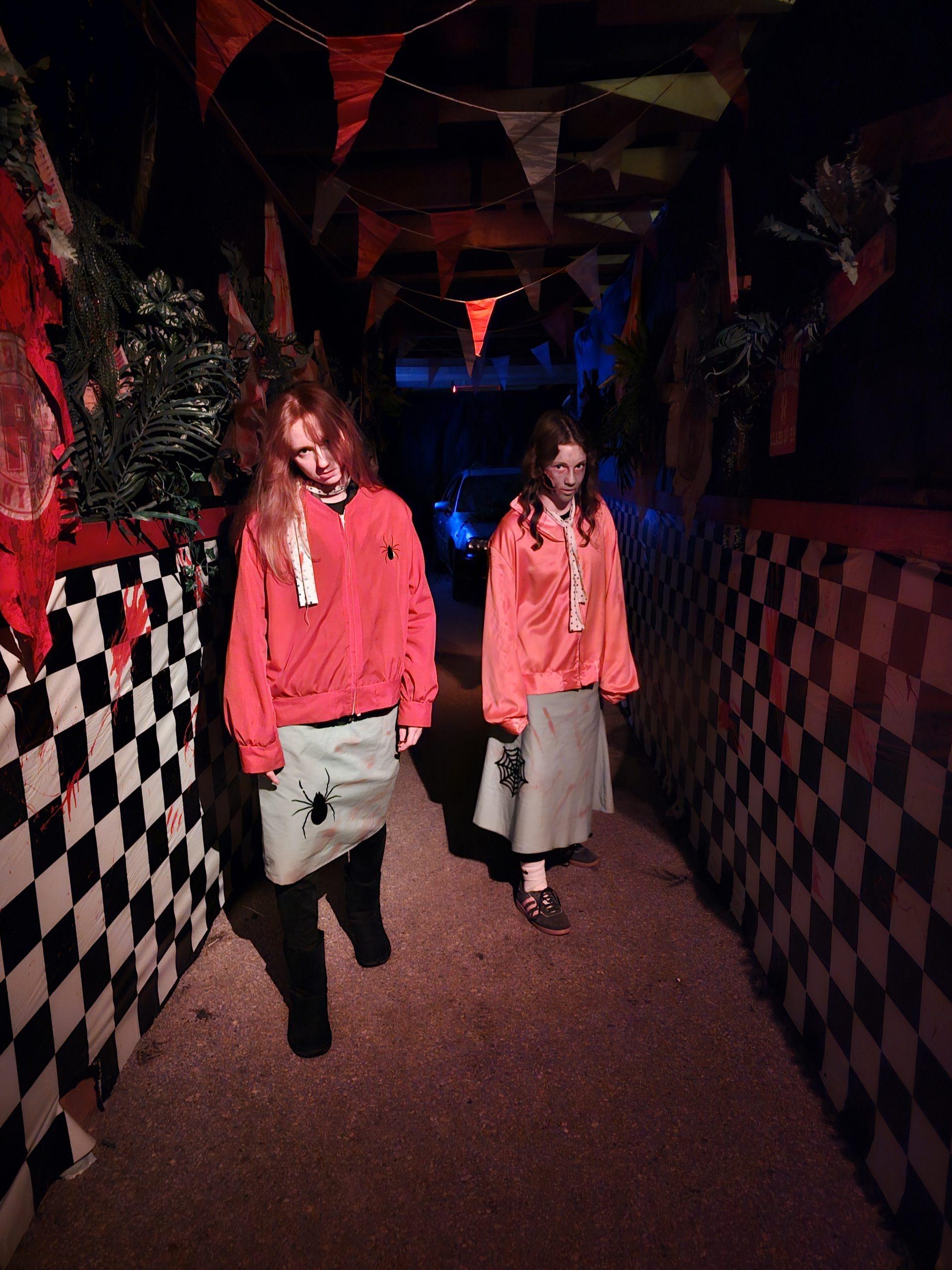Two ghostly figures in a checkered corridor
