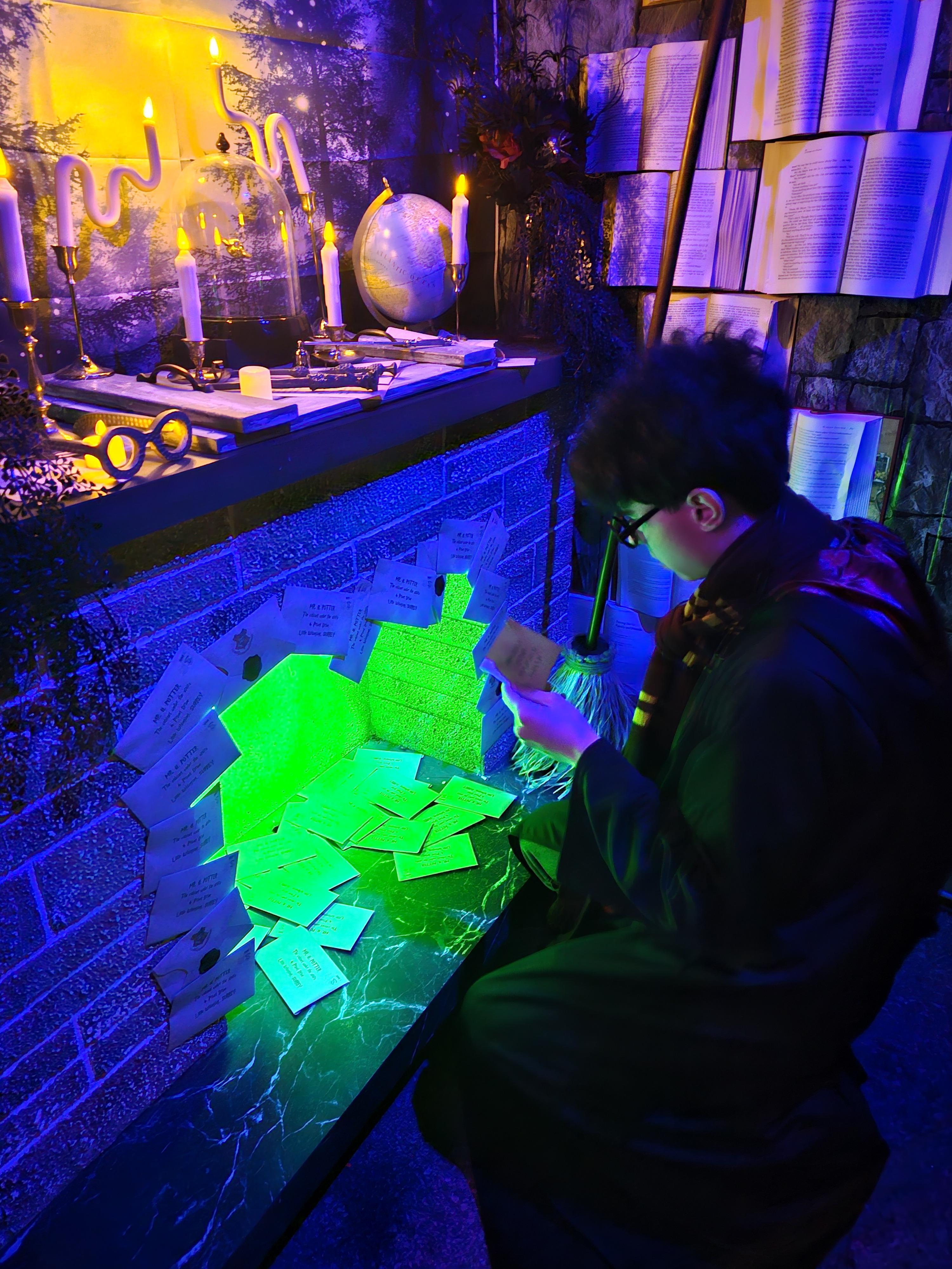 A figure hunched over a glowing potion table