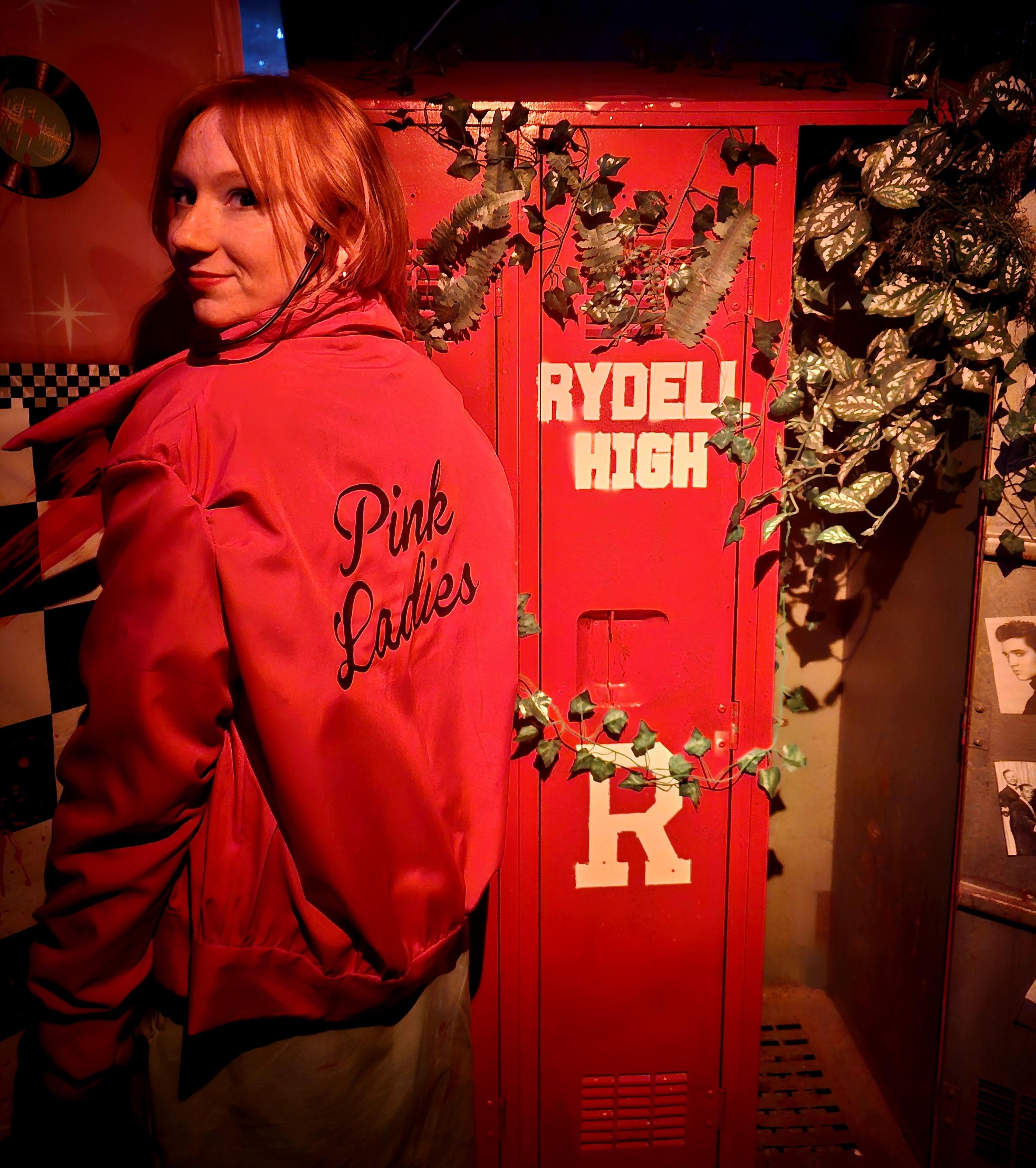 A costumed actor beside the red locker set