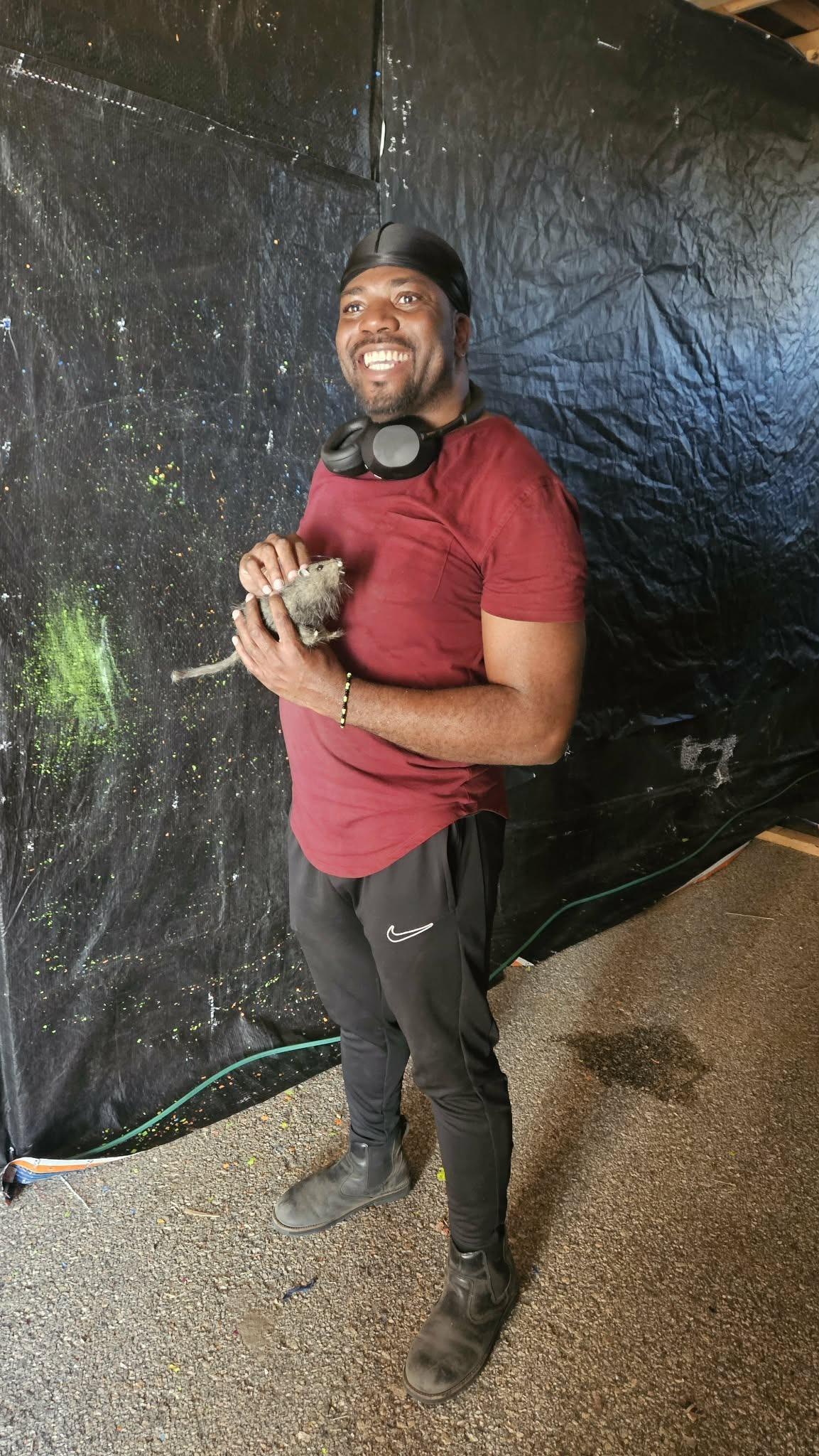 A volunteer grinning with one of the haunt's creatures