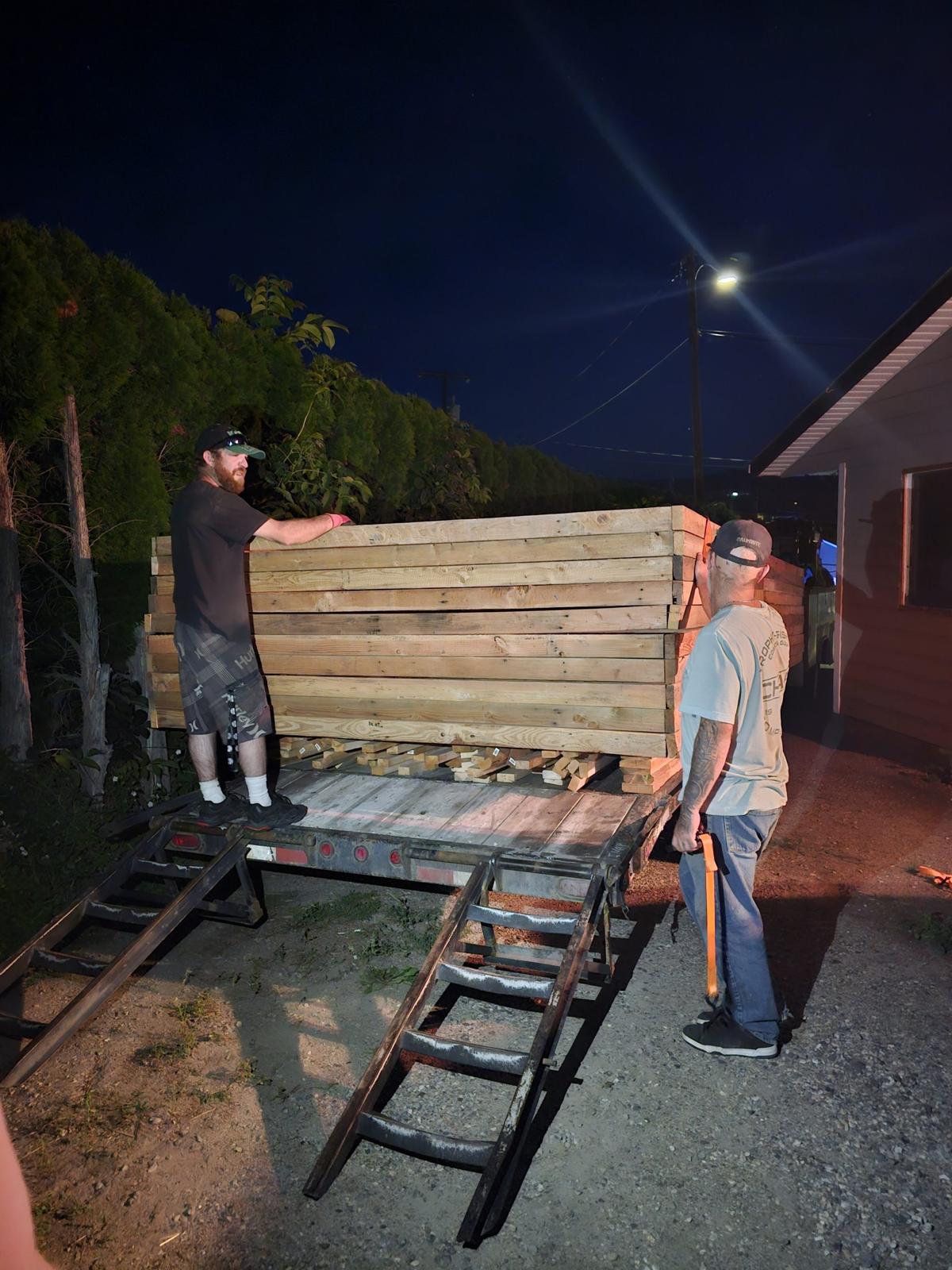 Volunteers hauling lumber after dark