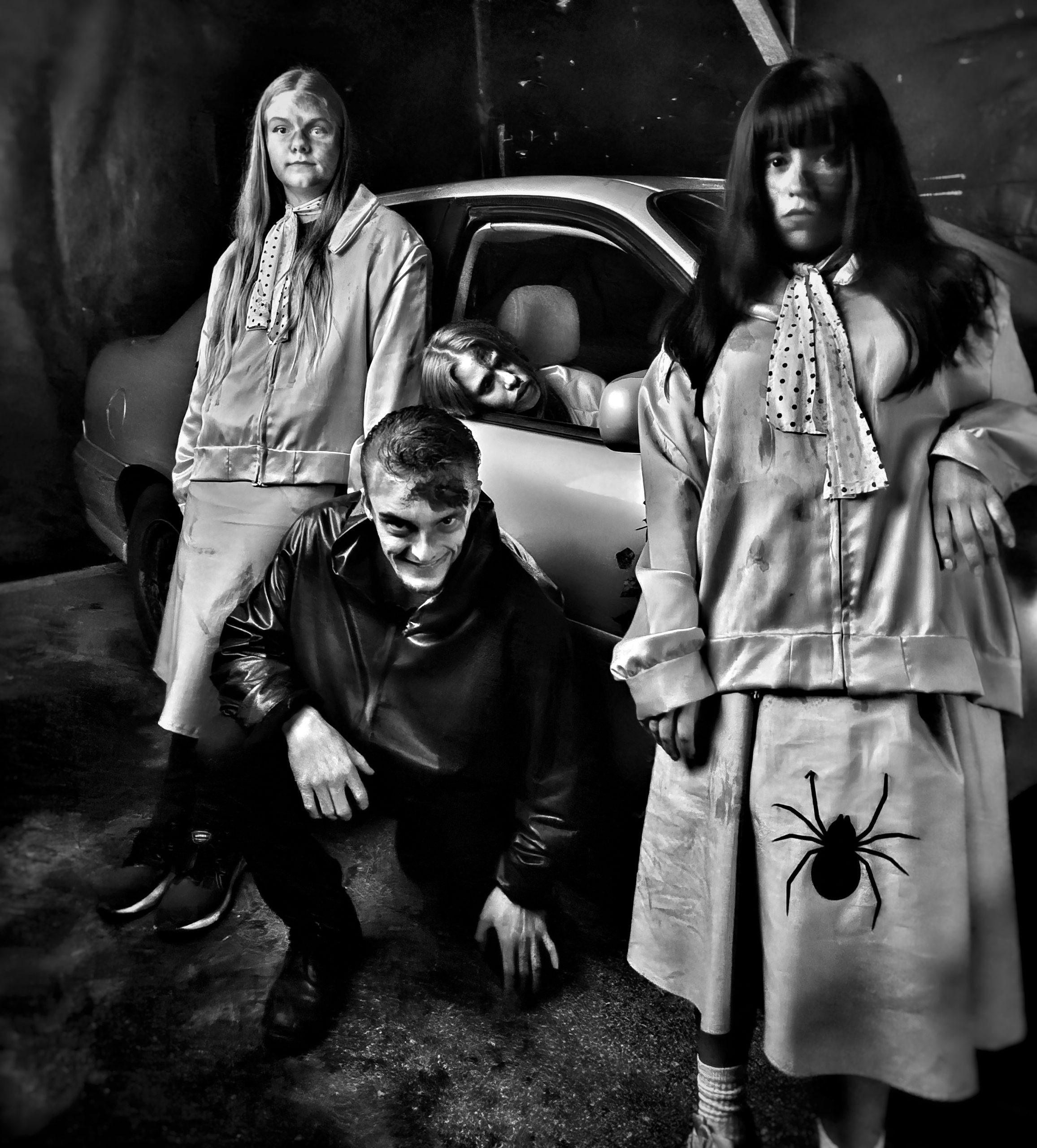 Two ghostly figures beside a car inside the haunt