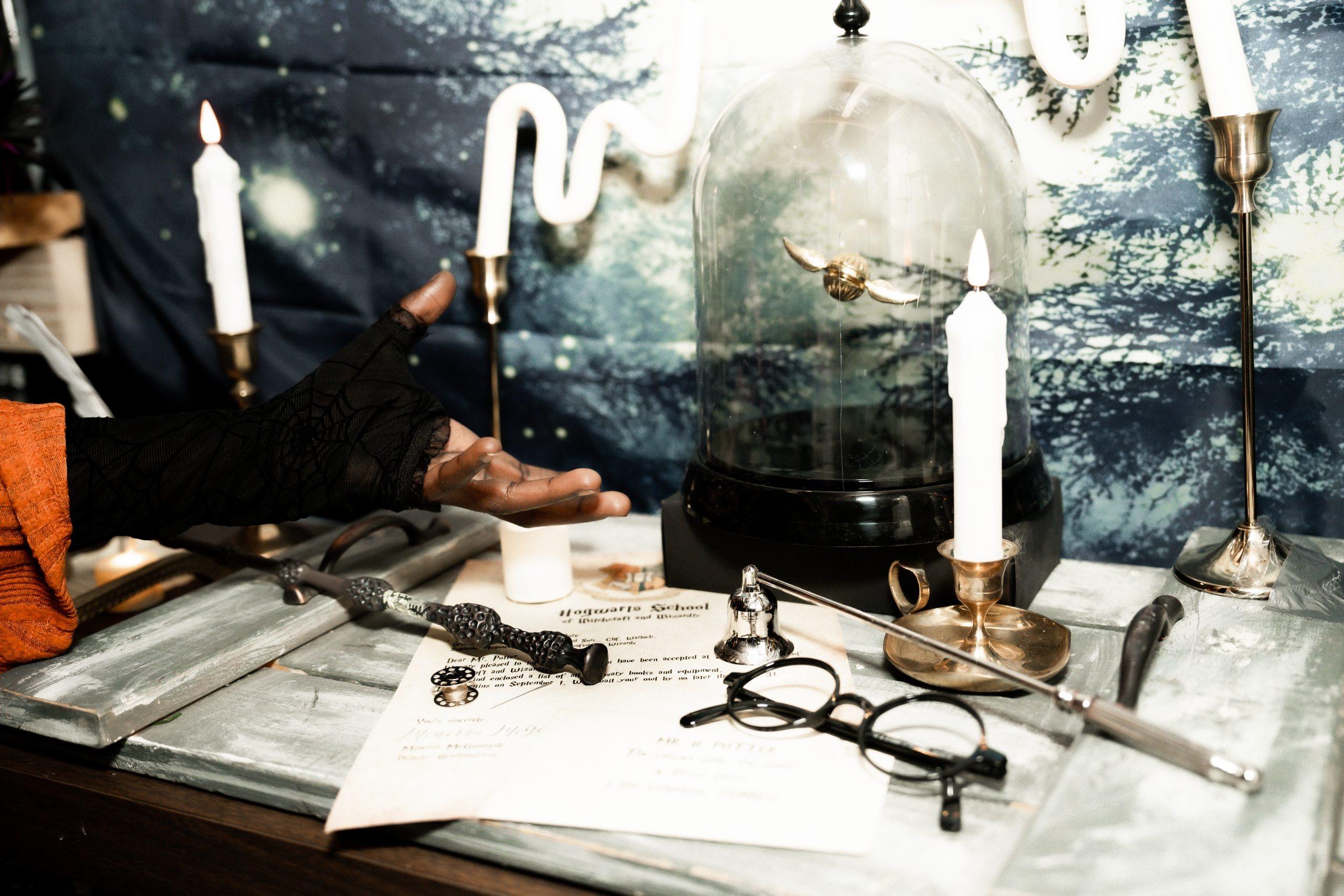 A candlelit desk of curiosities inside the haunt